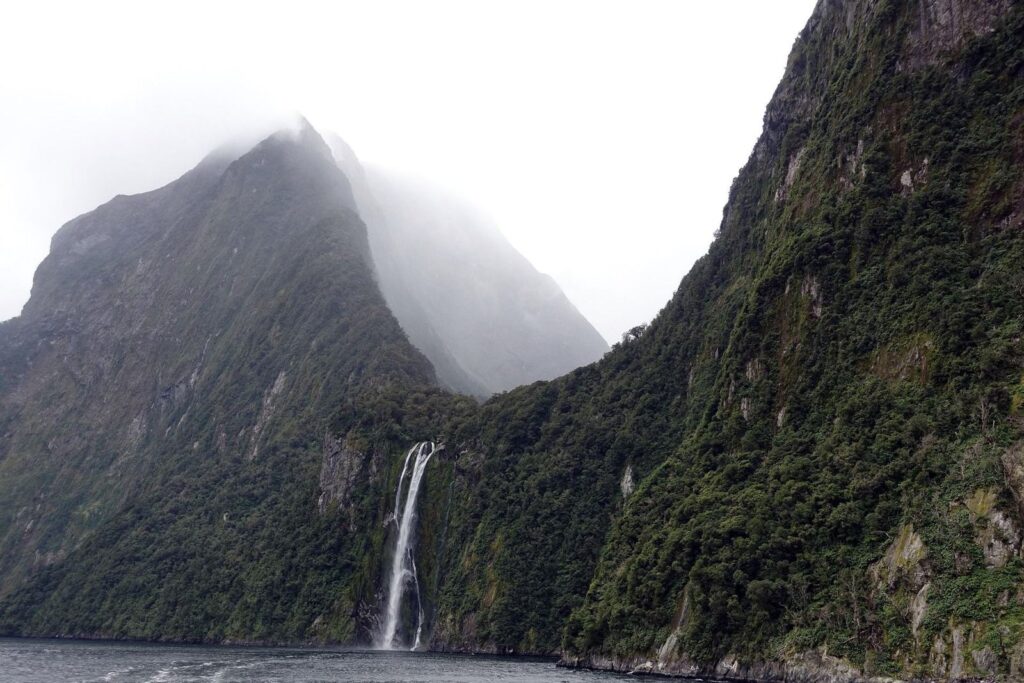 Cloud-covered cliffs and waterfalls at Milford Sound